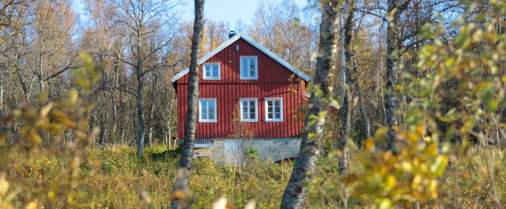 Punainen omakotitalo syksyisessä maisemassa